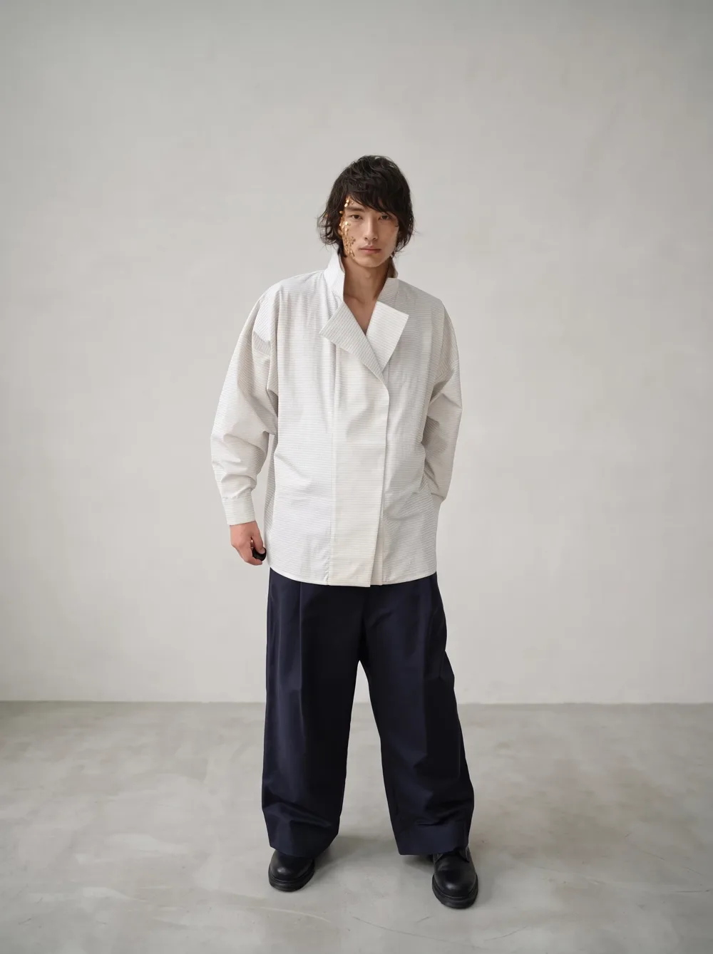 Hanpi White et pantalon sombre : des volumes unisexes et une ligne épurée.